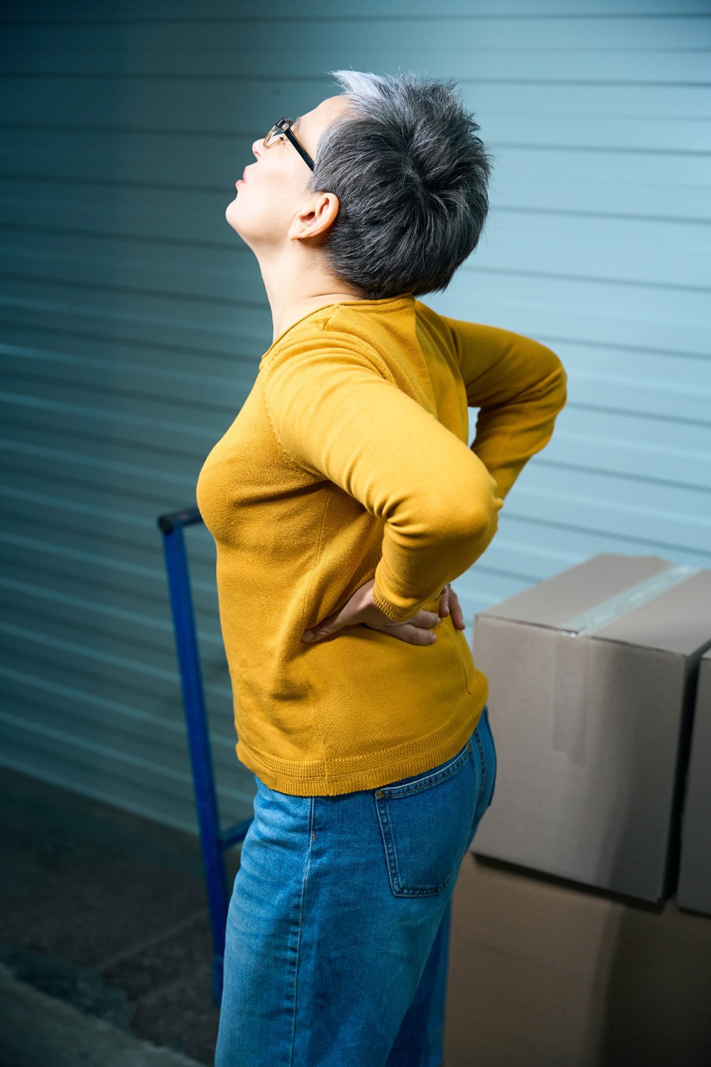 woman with back pain from moving boxes