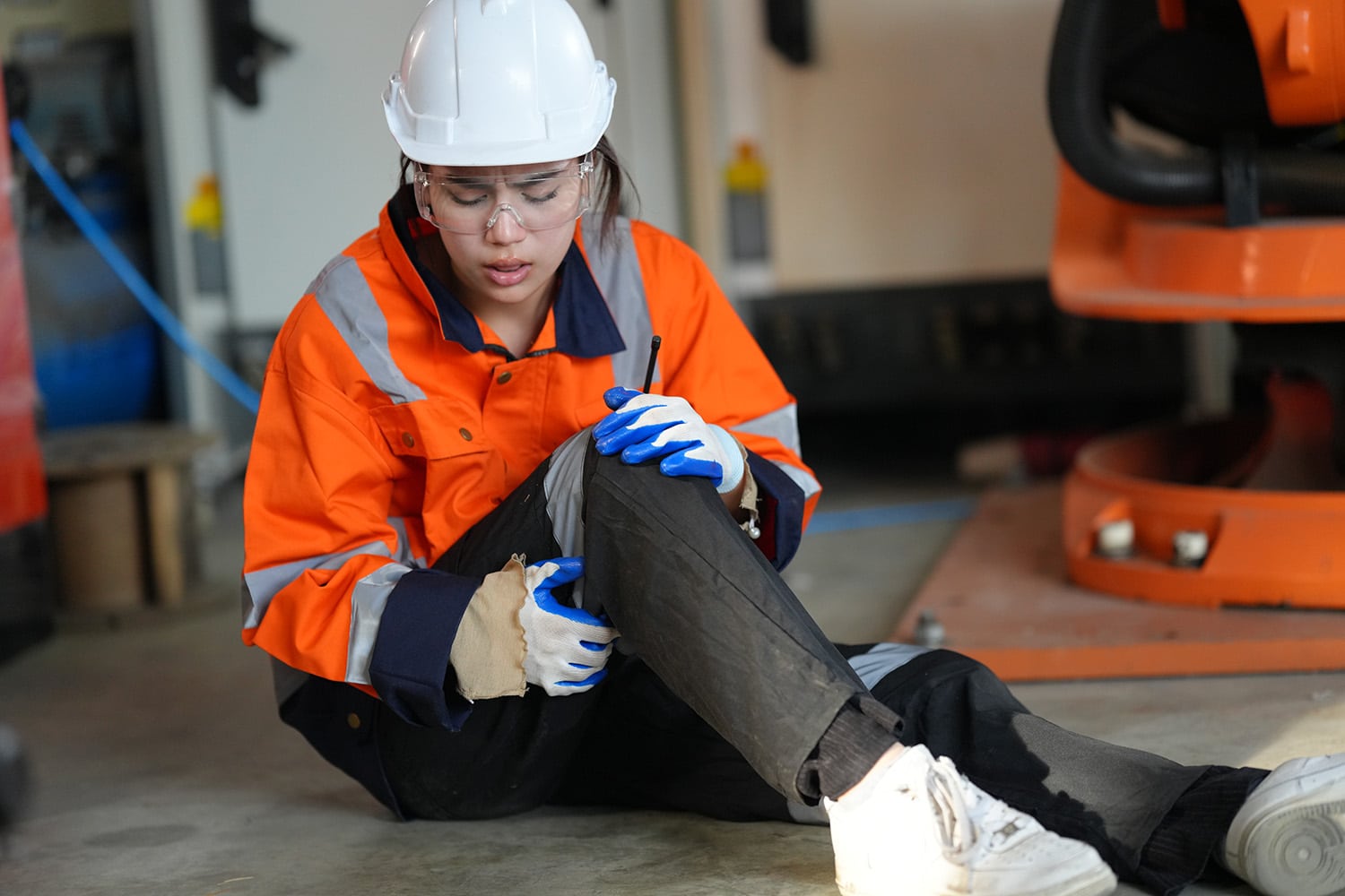 woman holding knee in pain at work