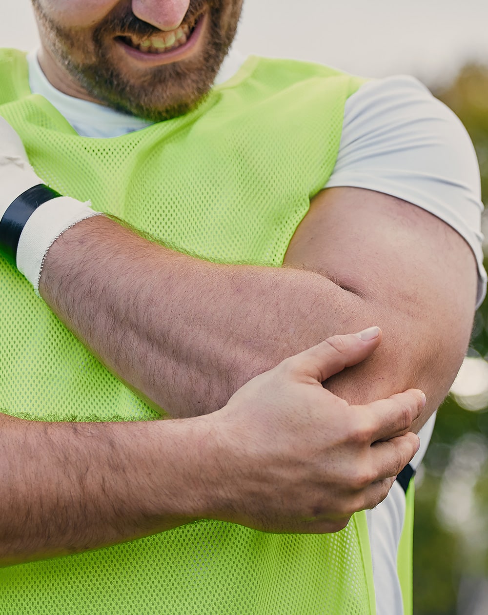 man holding elbow in pain