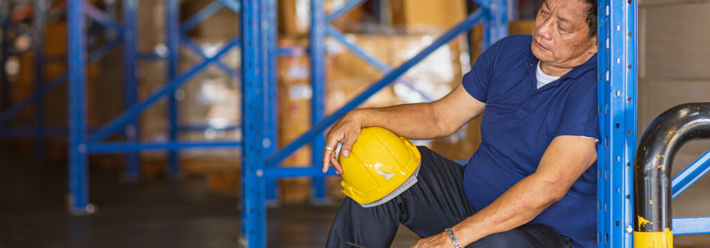 man sitting in warehouse after injury